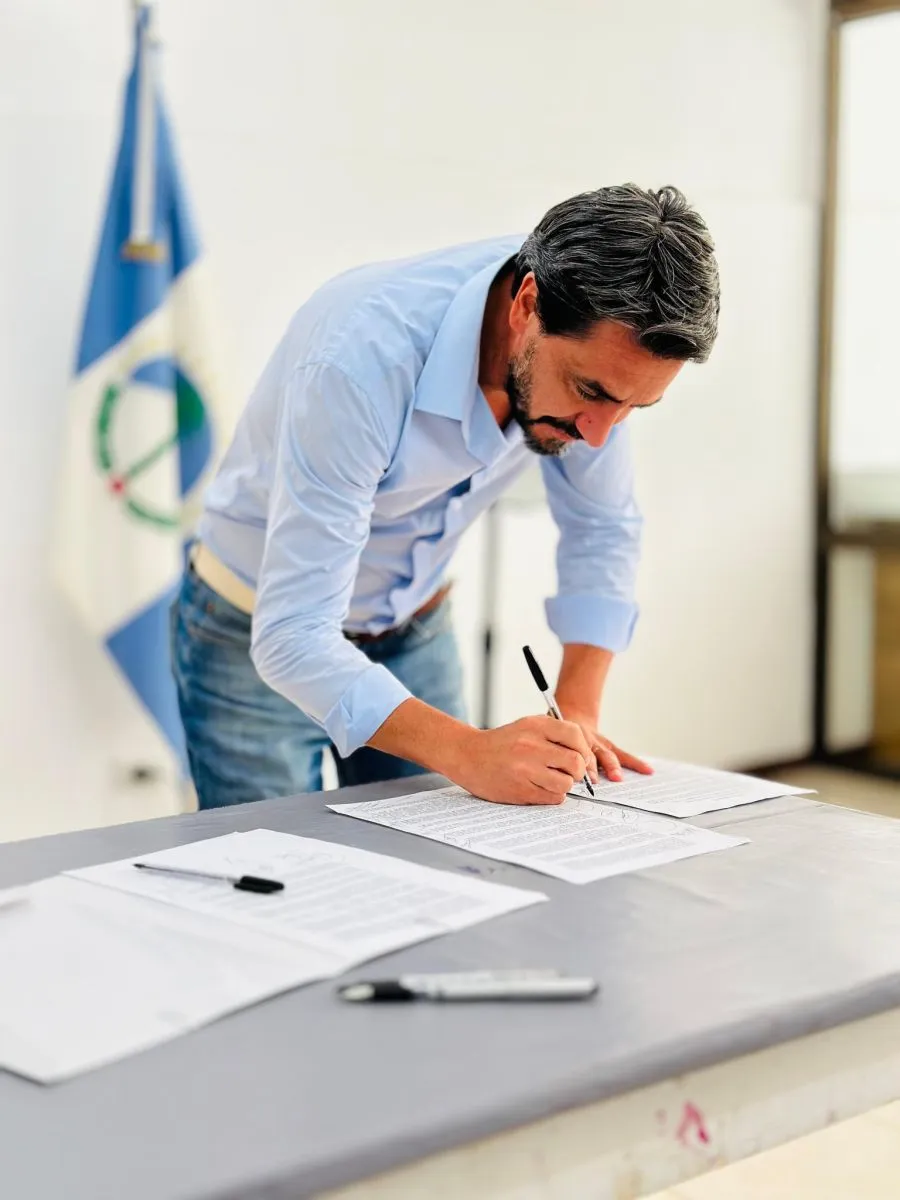 Carlos Saloniti firmando el "pacto de gobernanza"